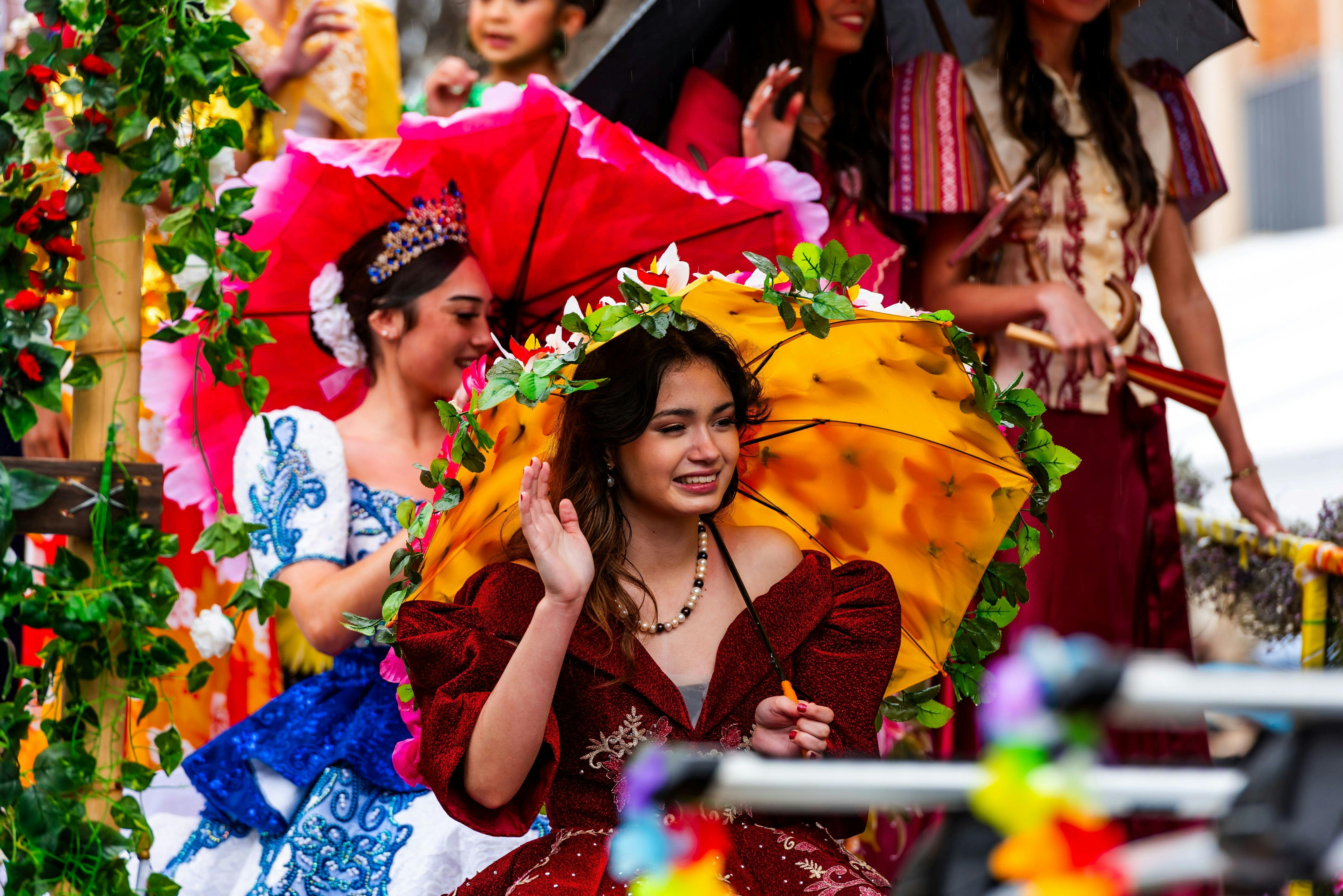 Women dressed as floral fairies parade under colourful umbrellas at Grand Central Floral Parade