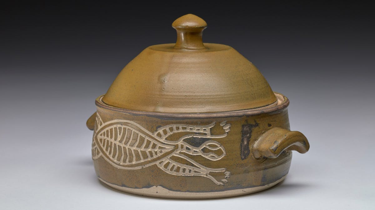 Glazed stoneware casserole with incised crocodile design