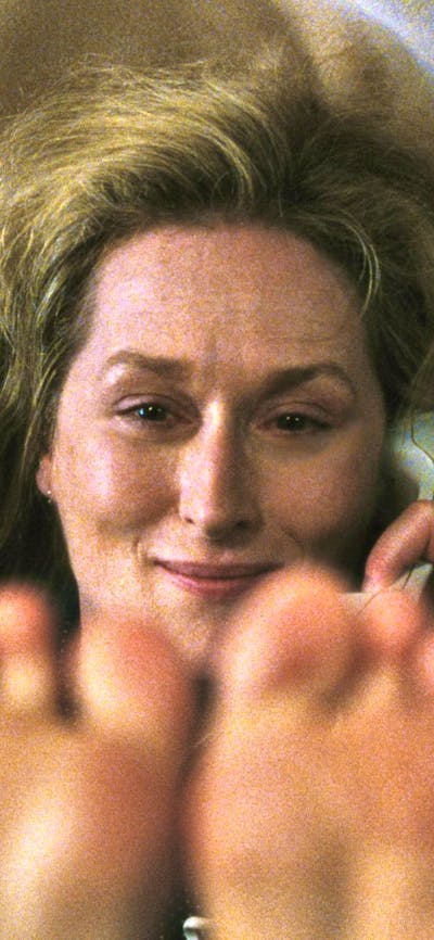Woman looks past camera, holding phone to ear with her feet in the air