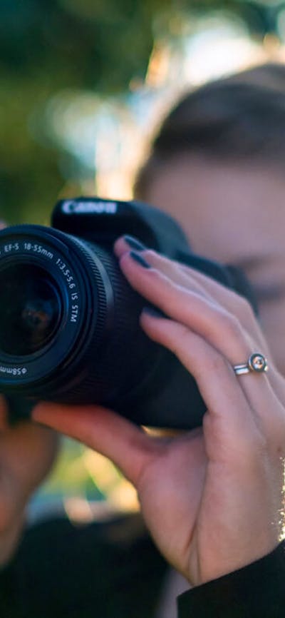 Photograph of a woman taking a photograph with a digital camera