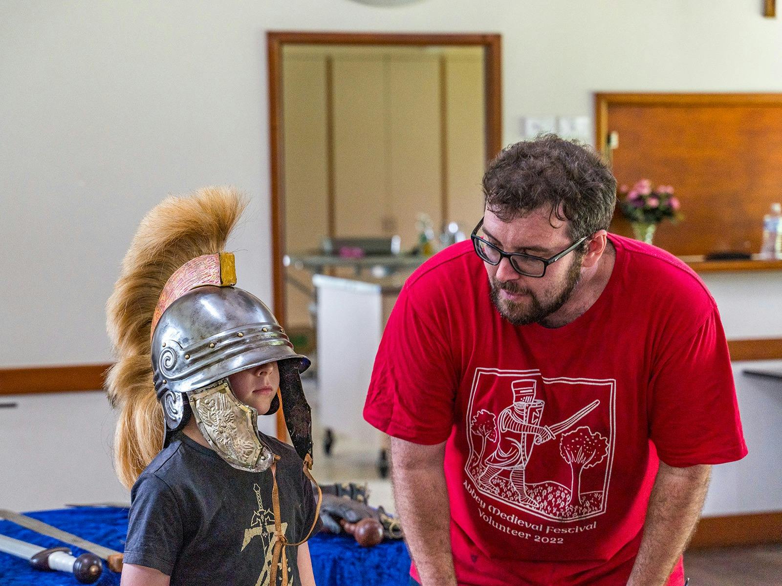 Child wearing Roman style helmet with Education Manager Benjamin