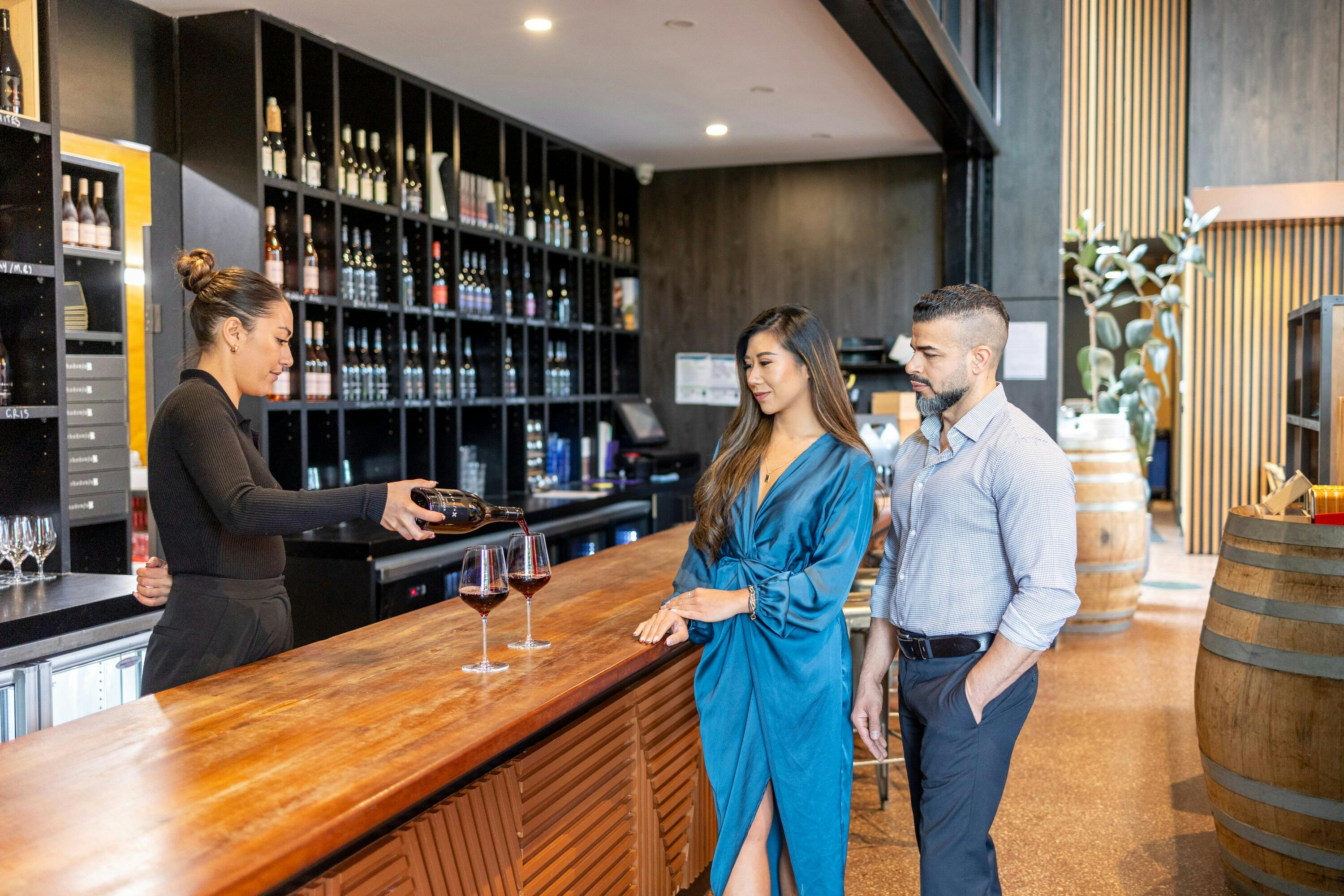 two adults enjoying a wine tasting in a cellar door