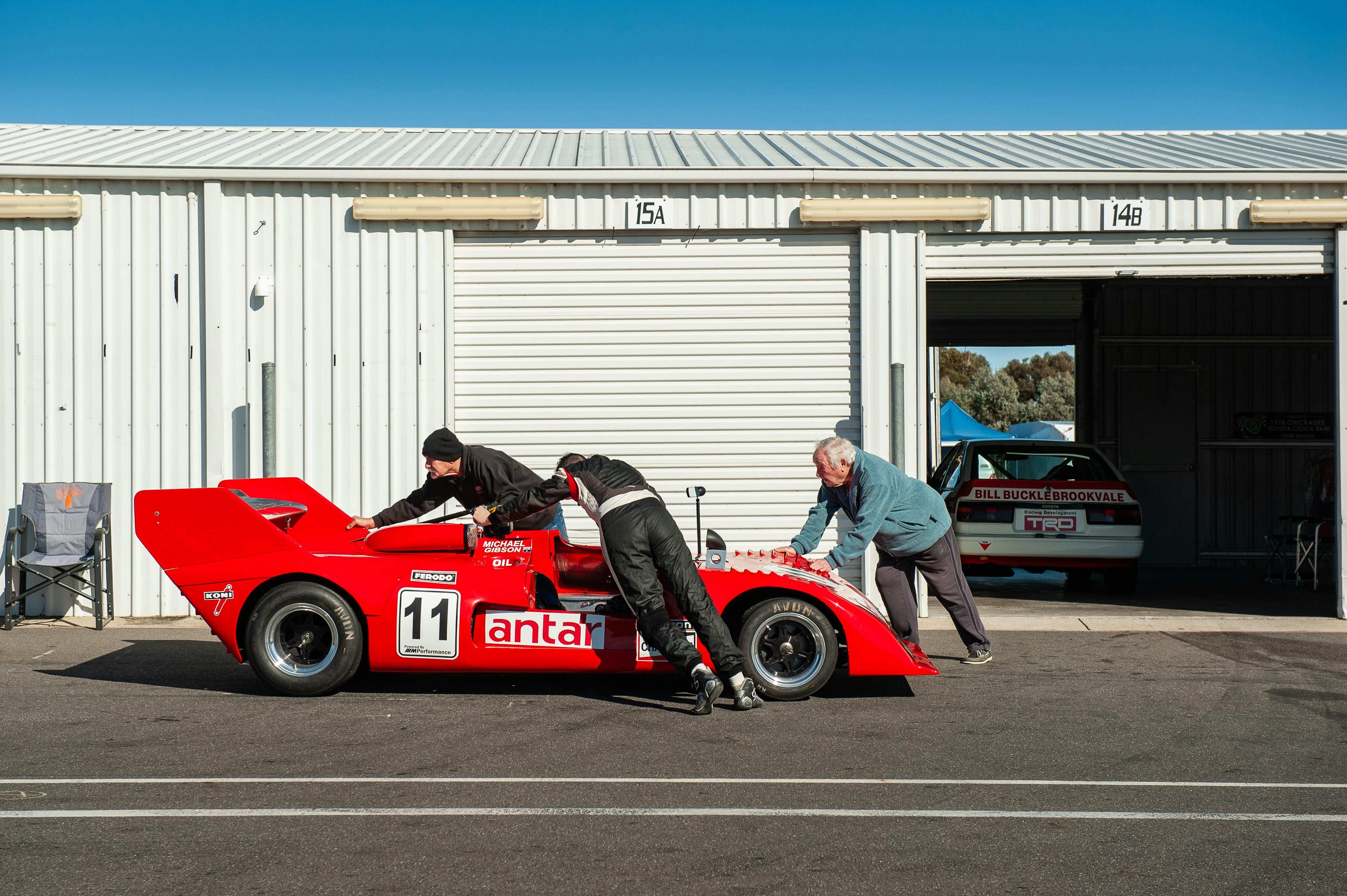 Sports car being pushed by people