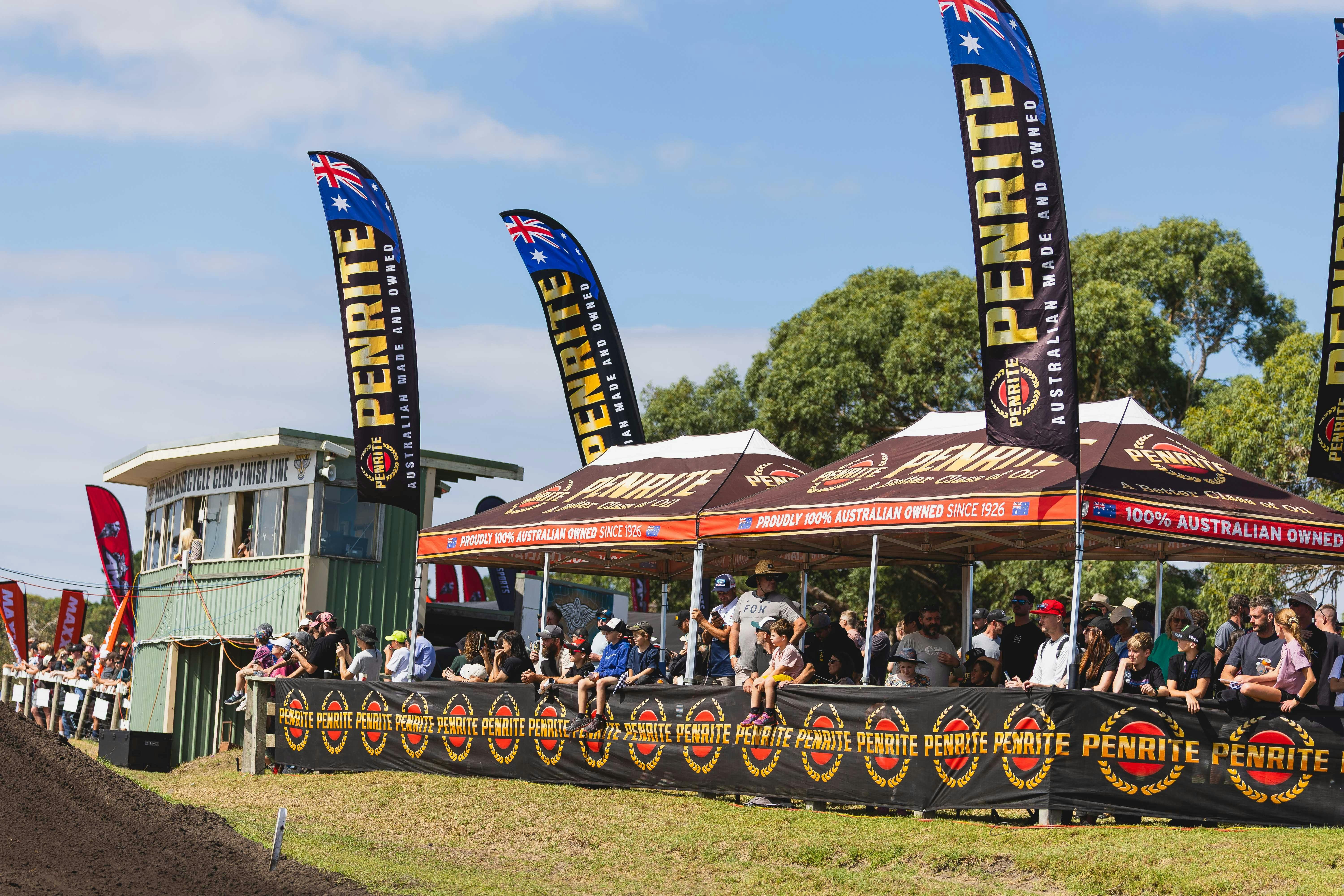 Spectators sit under the viewing gazebo