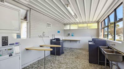 Clean and spacious coin laundry with washing machines, dryers, and folding space