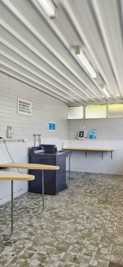 Clean and spacious coin laundry with washing machines, dryers, and folding space