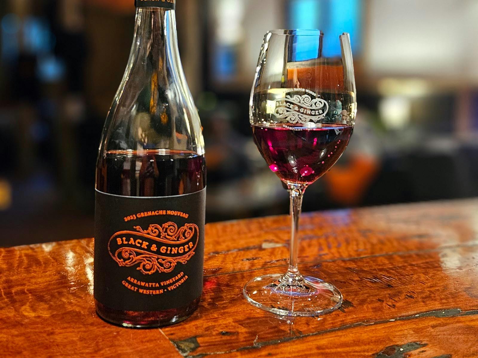 A bottle and glass of Black & Ginger Grenache Nouveau on the bar at the wine shed