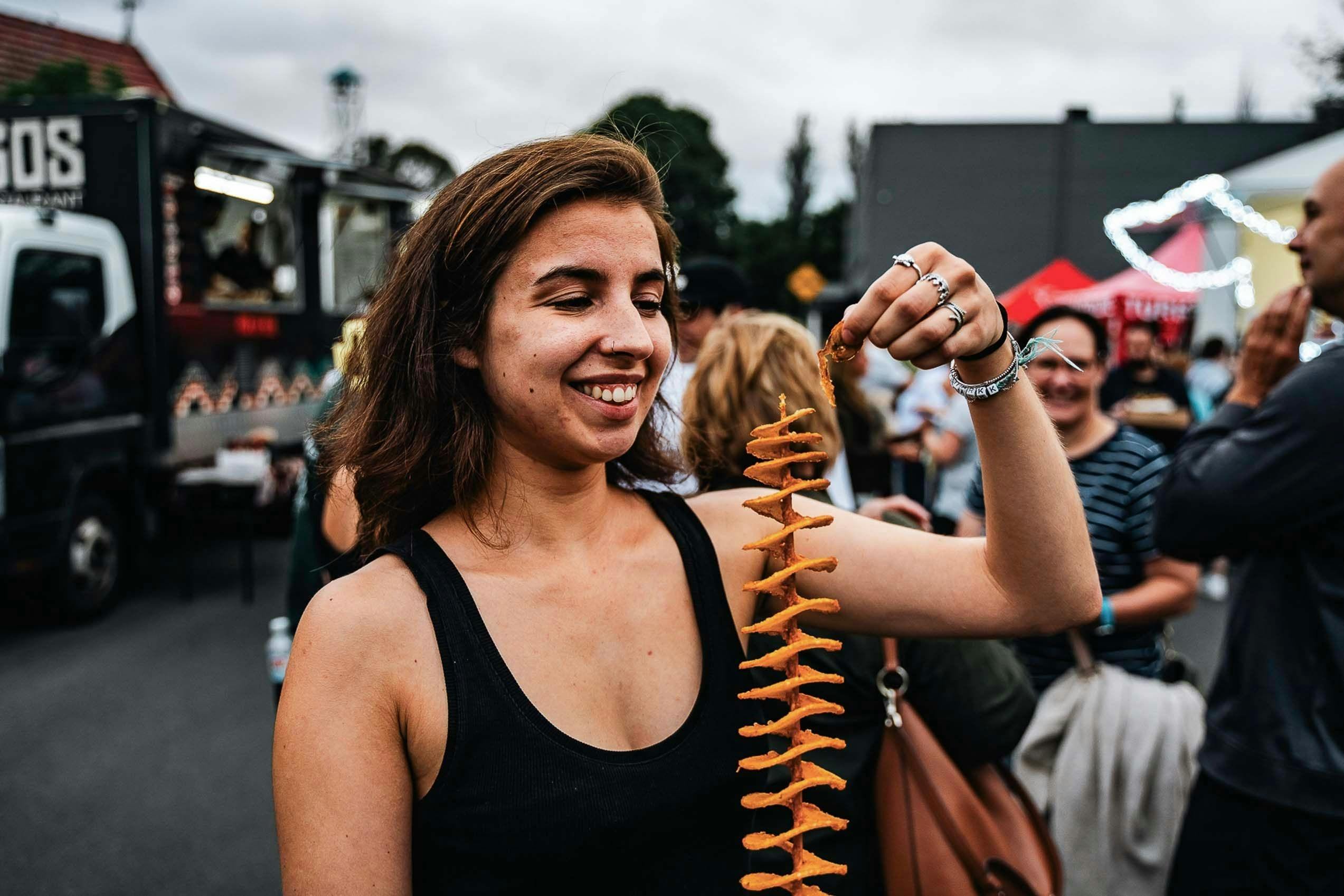 Woman enjoying a potato on a stick