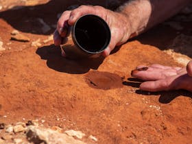 Uncle Ken making paint from natural ochre clay by the ocean