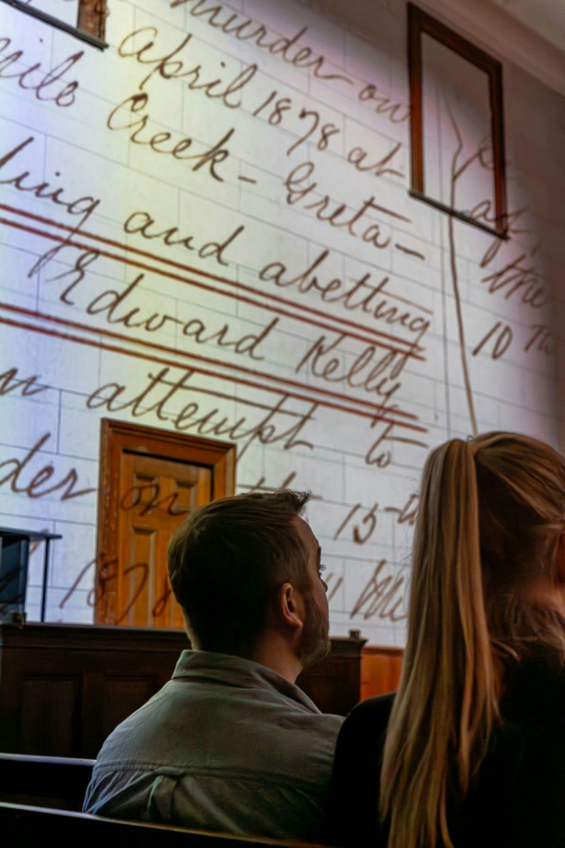 Projections of images and words cover the walls from ceiling to the roof