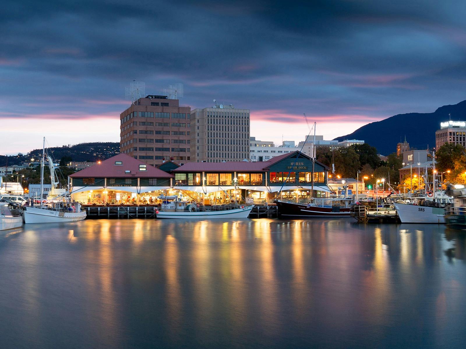Photo depicting Mures Fish Centre, a large building on the dockside with boats surrounding it