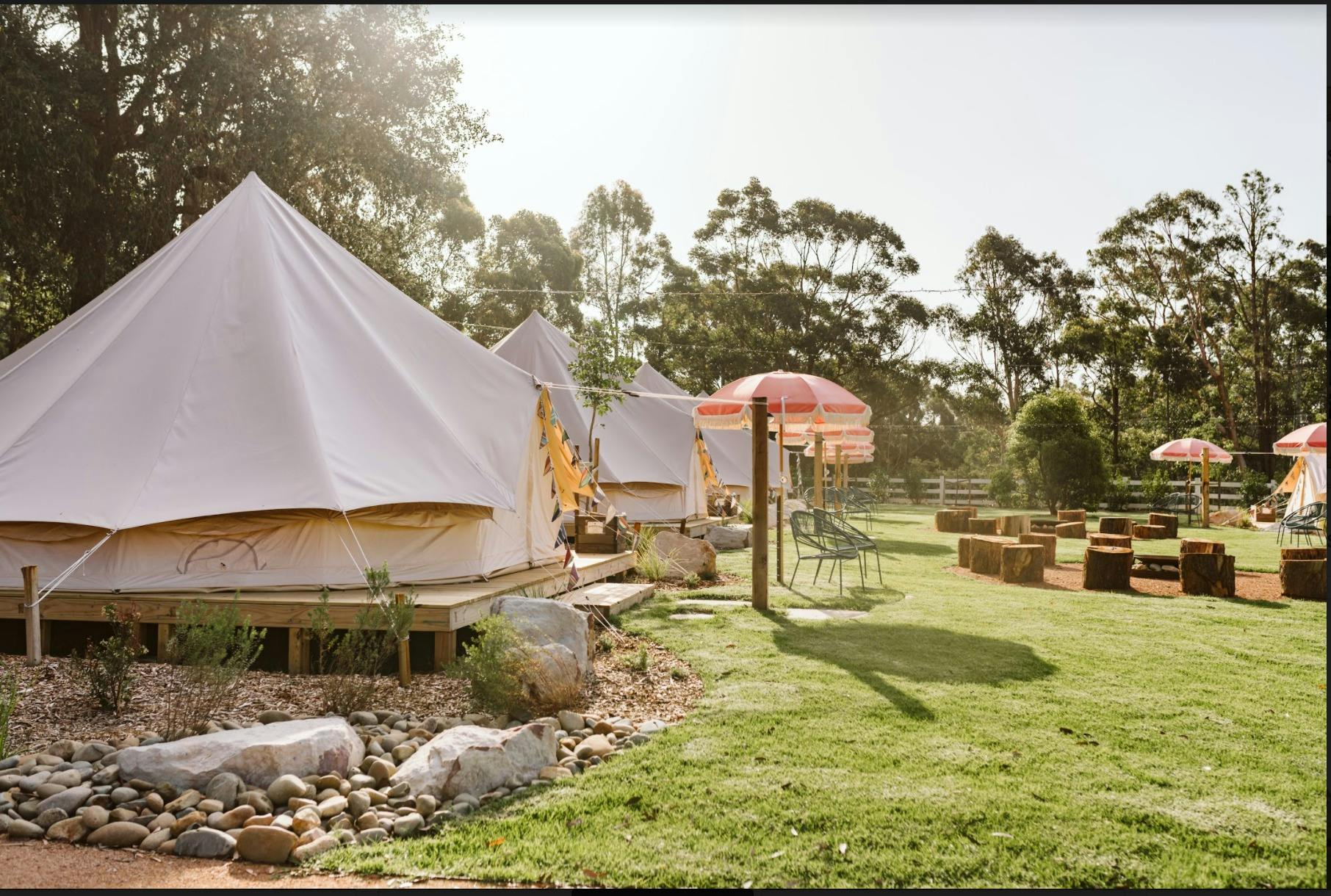 着席エリア用のファイヤーピットと屋外傘を含むグランピングビレッジ