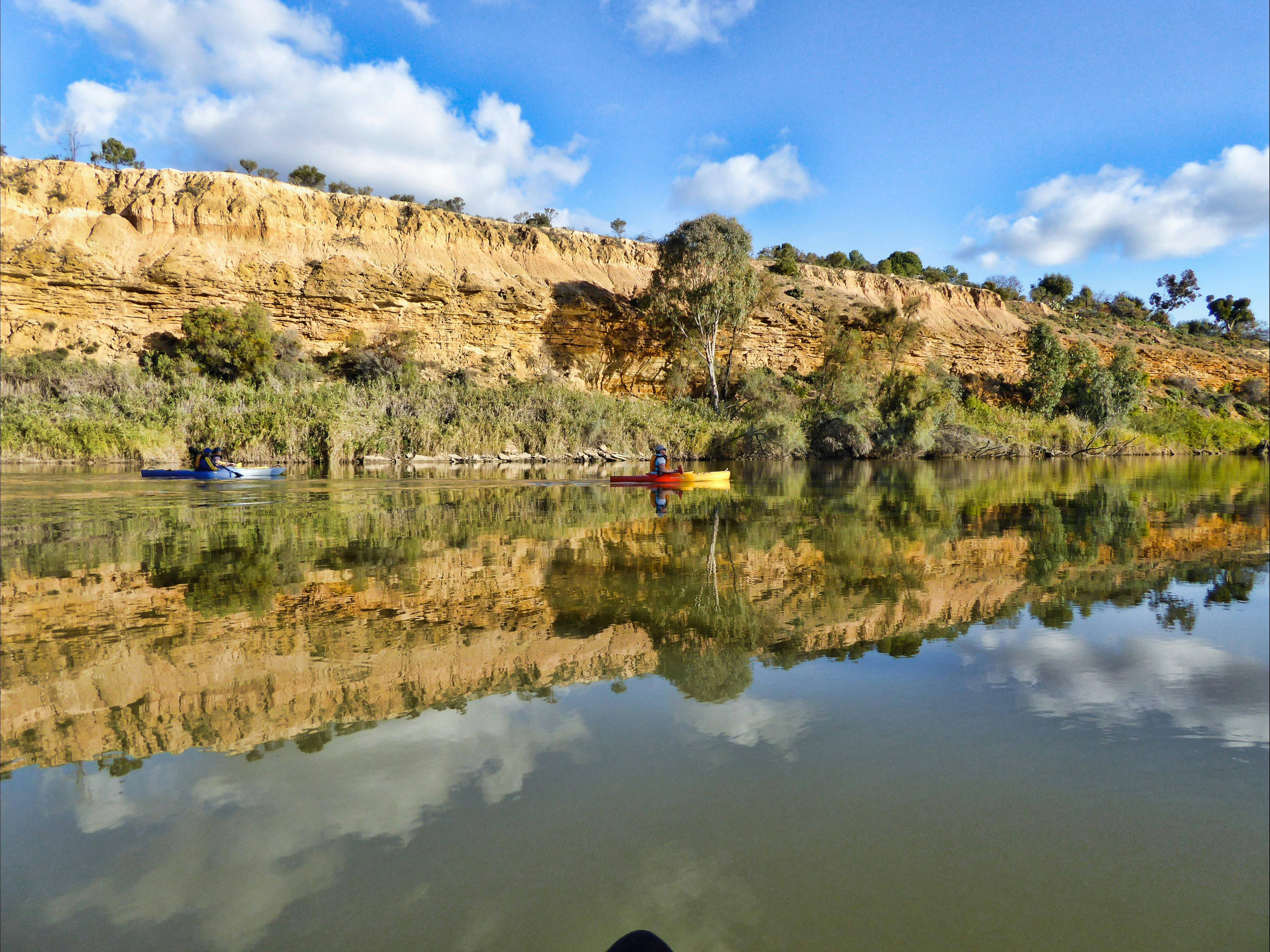 Kayakers by magnificent Murray River cliffs.