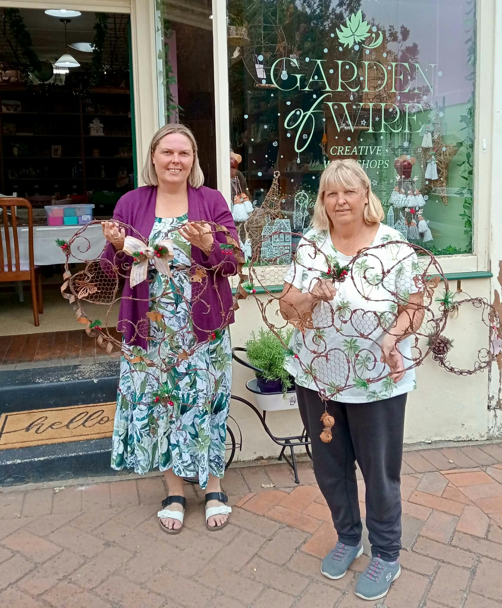 Two women standing in front of the shop with the Embellished Hearts of Wire they have made