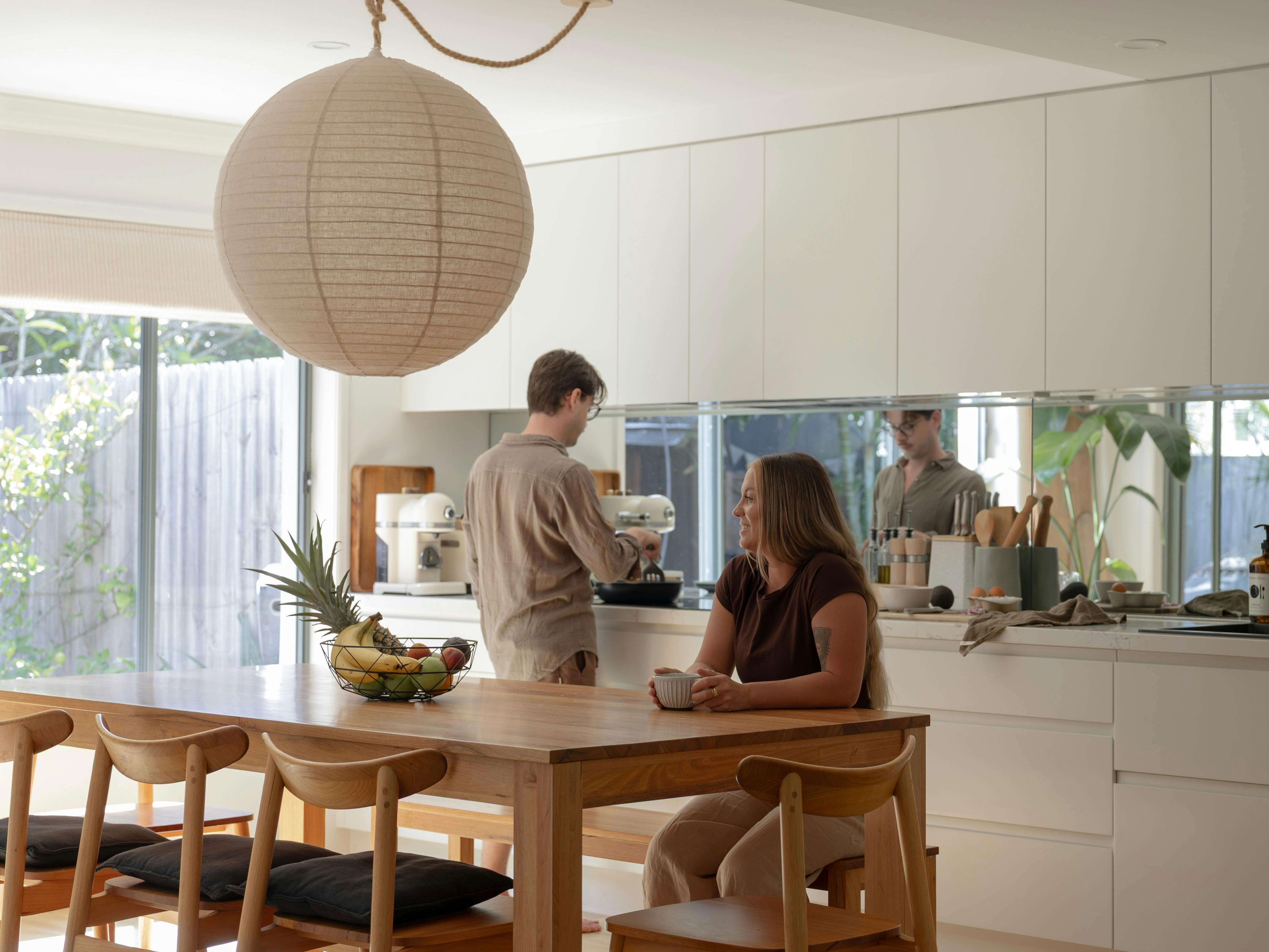 Young couple cooking breakfast in sunny kitchen with round linen pendant lantern