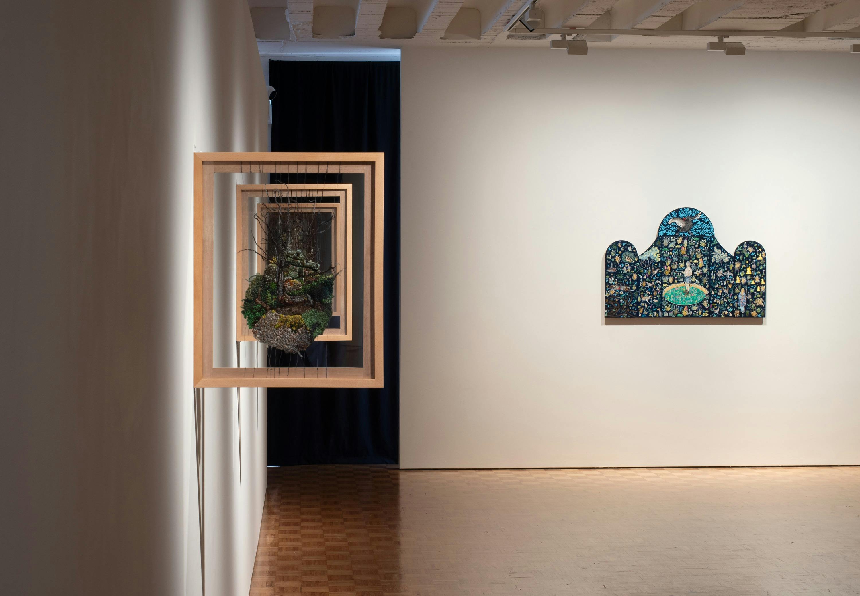 Embroideries depicting native tree species hang in their frames, suspended by silk threads.