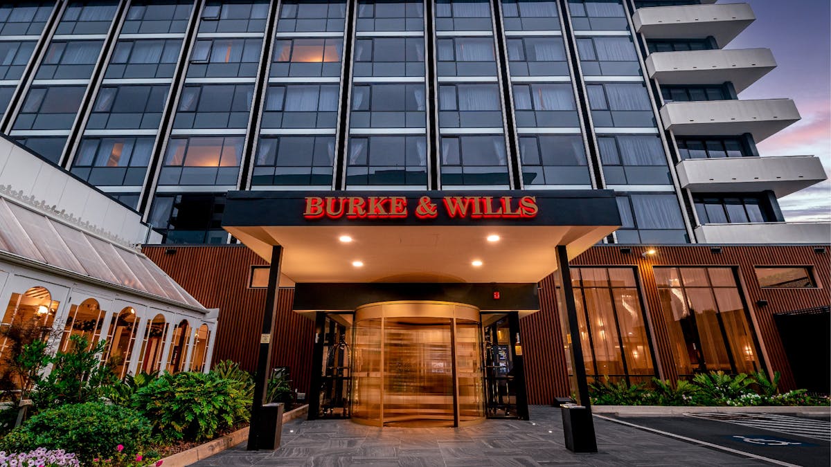 Exterior of the Burke & Wills Hotel featuring the golden revolving door to the reception entrance