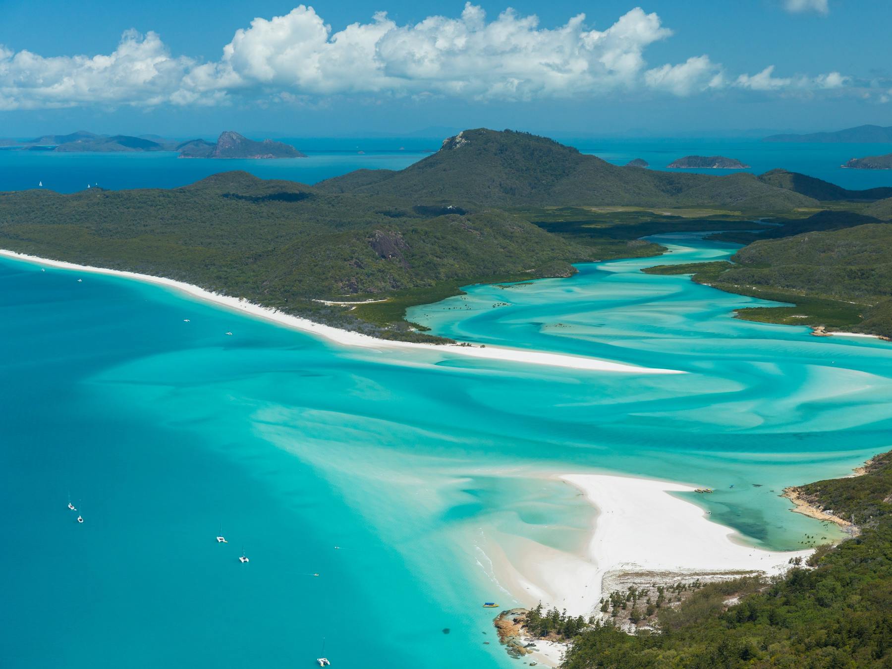 Aerial view of the swirling fusion of white sand and turquoise water into the inlet