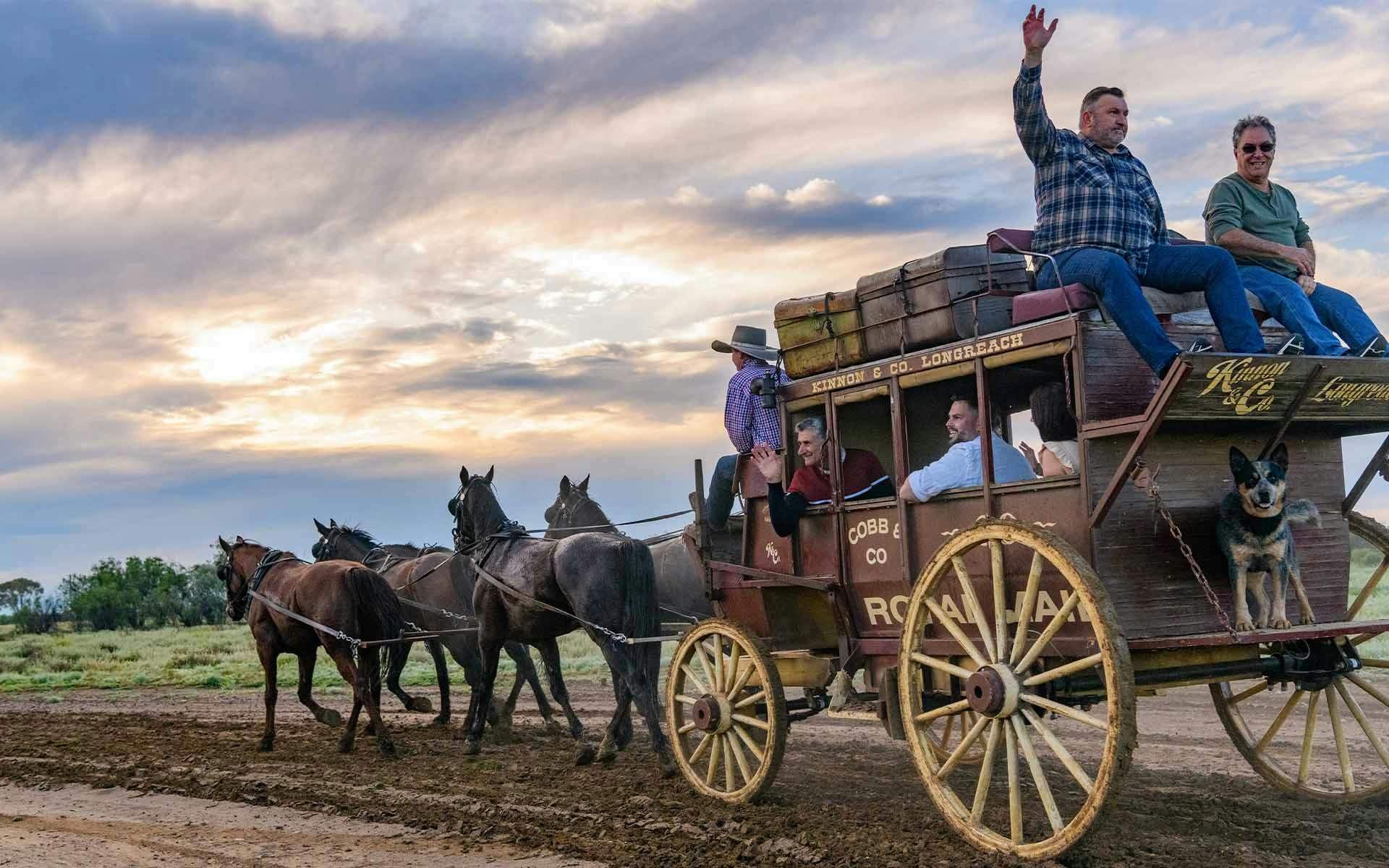 Guests waving atop the Cobb & Co Stagecoach