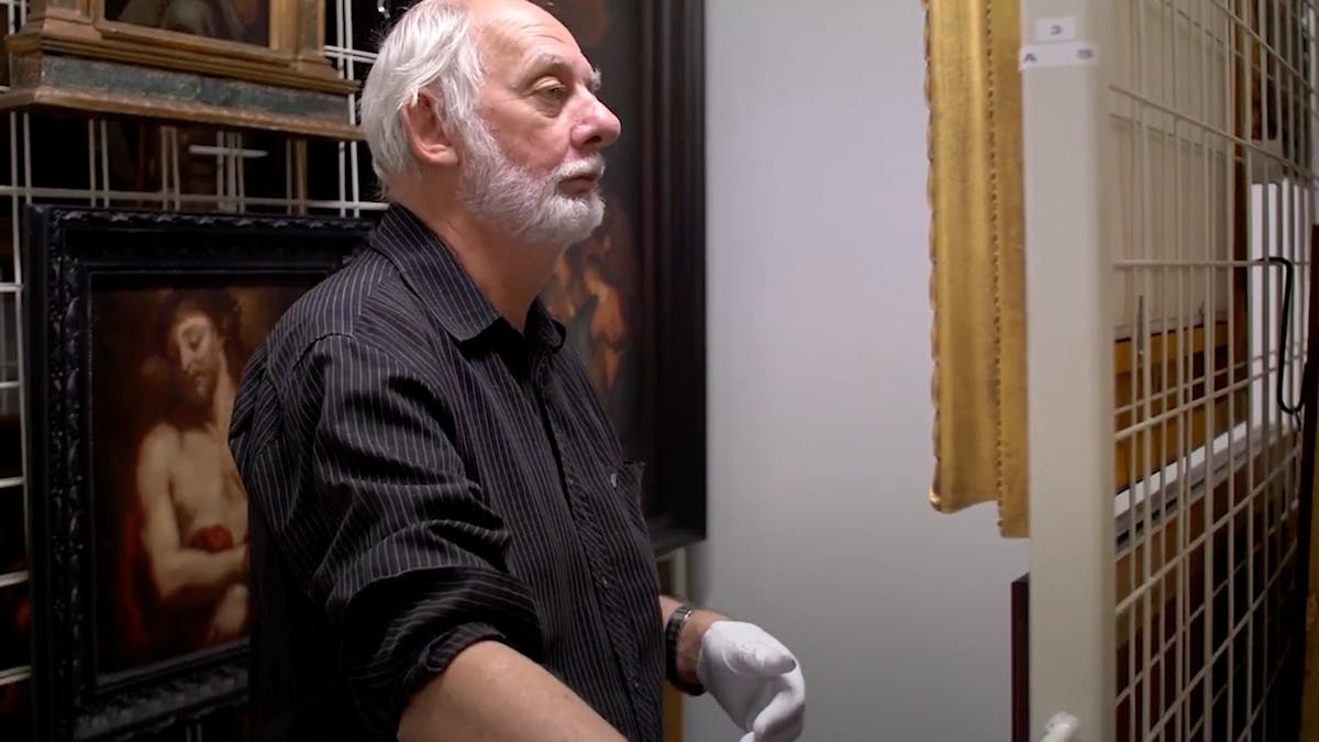 Senior Curator inside collections room with artwork
