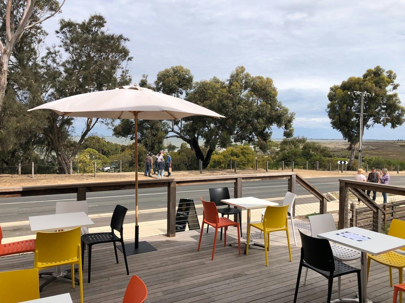 Kanoetree Wines Cellar Door  Outdoor deck with chairs tables and shade umbrella