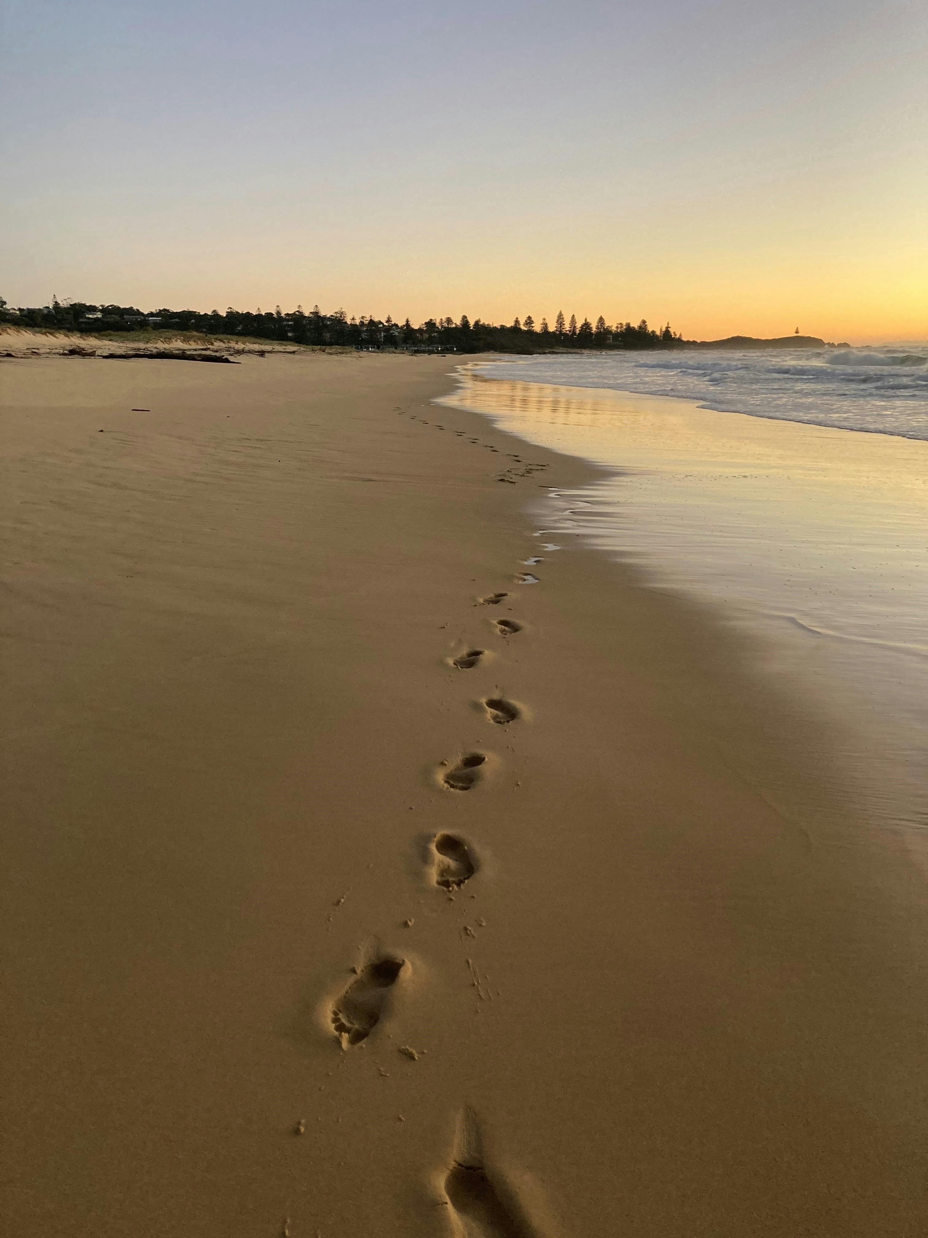 Barefoot footprints in the sand looking down the coastline towards Tuross Head from Potato Point.