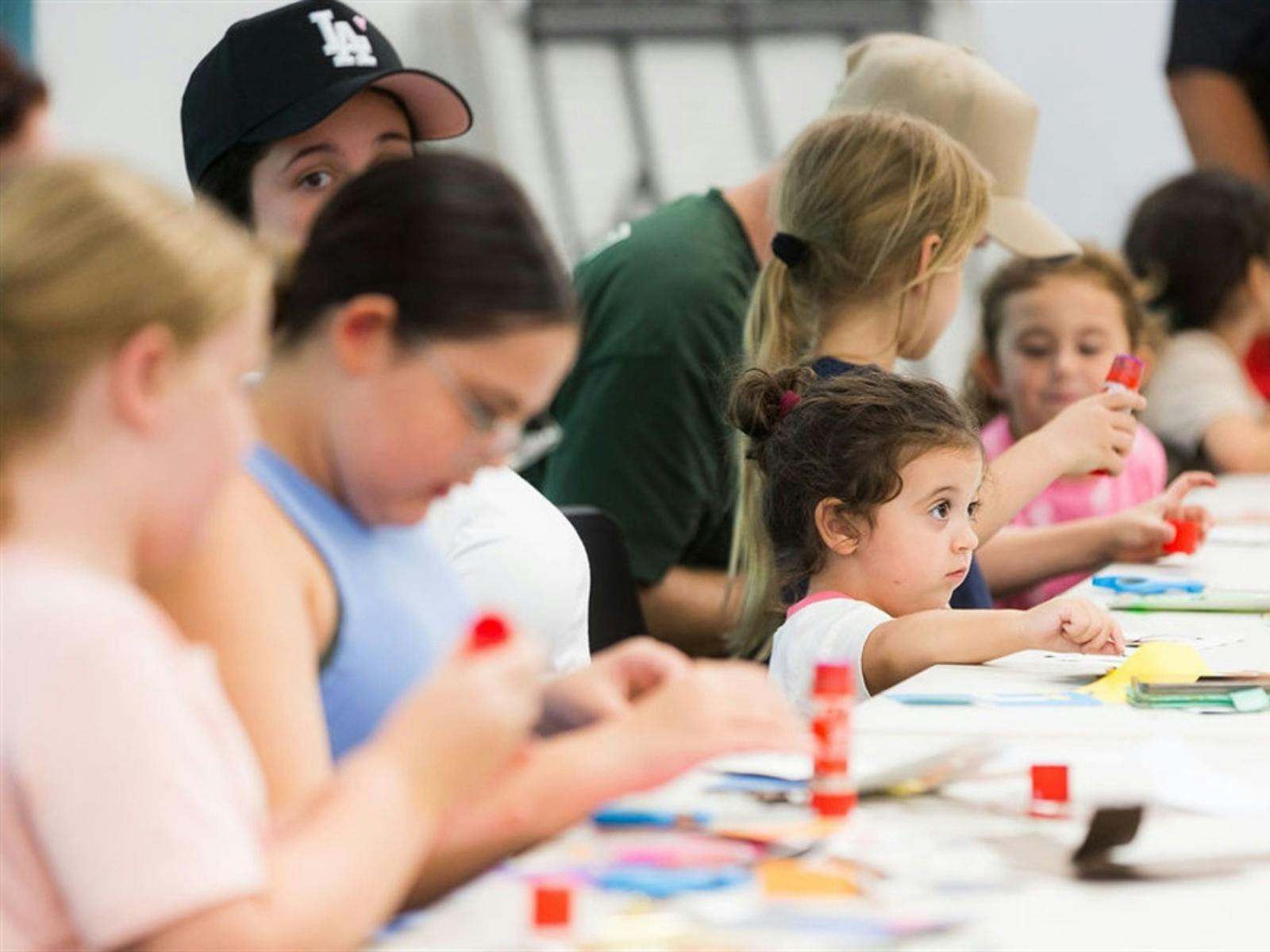 Photograph of children gluing down paper at a table