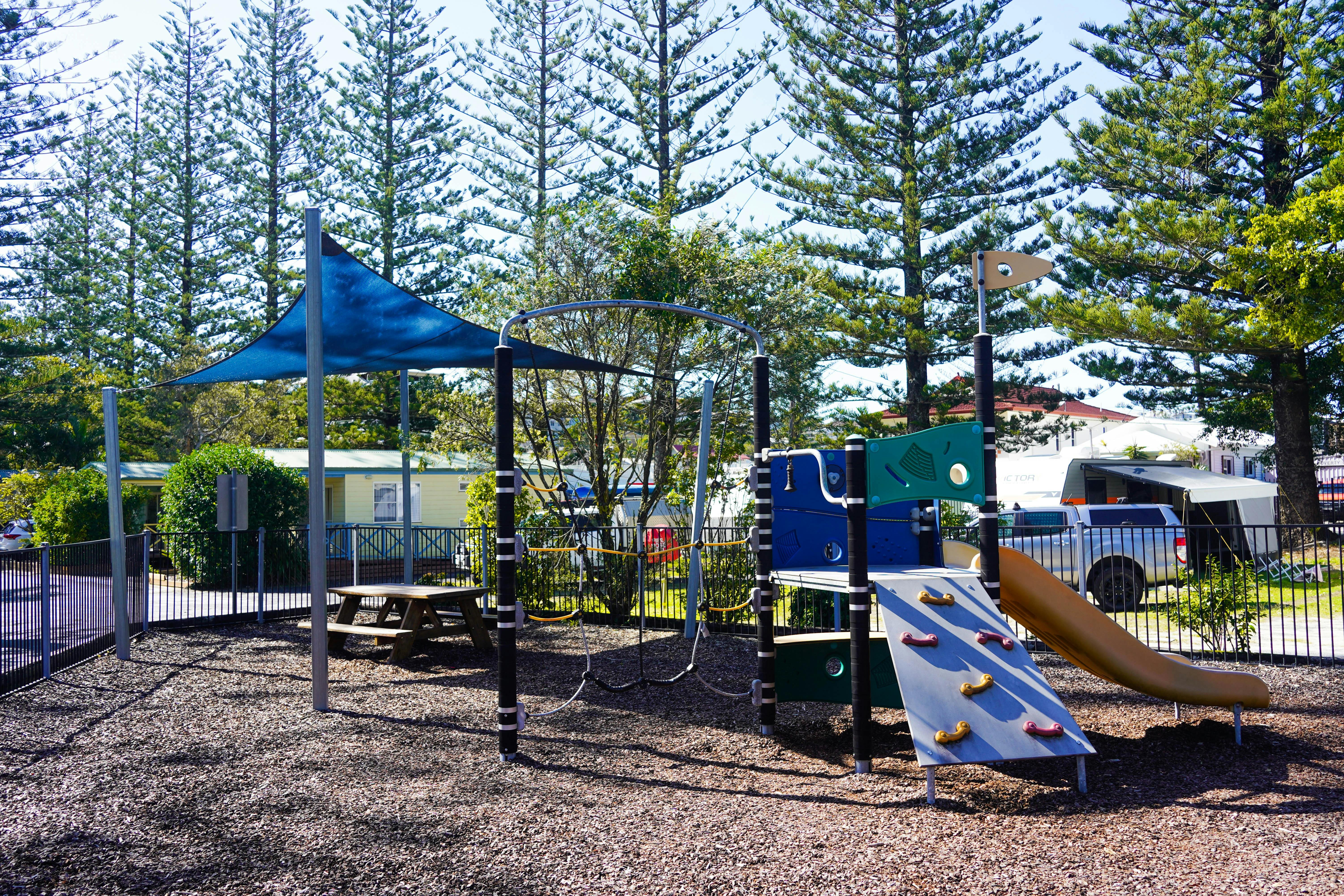 露營區旁邊有一個帶滑梯的色彩繽紛的遊樂場。