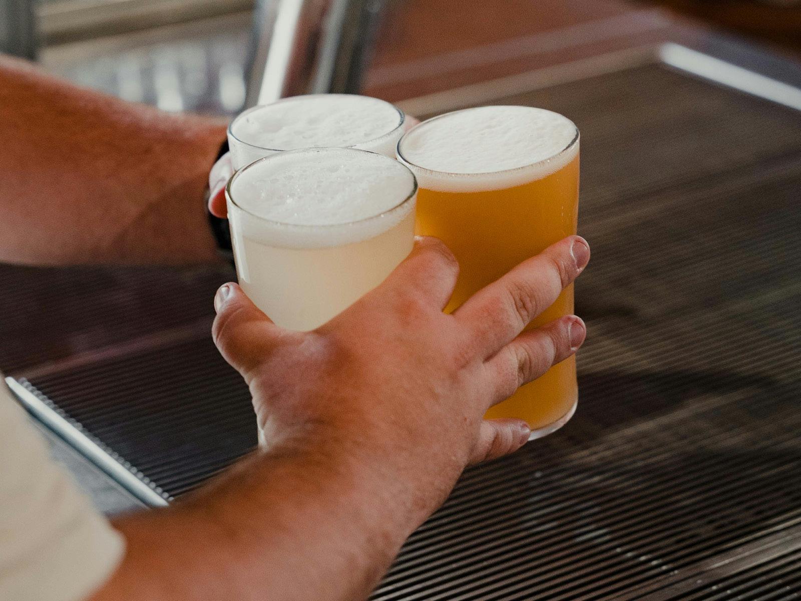 Hands picking up three beers