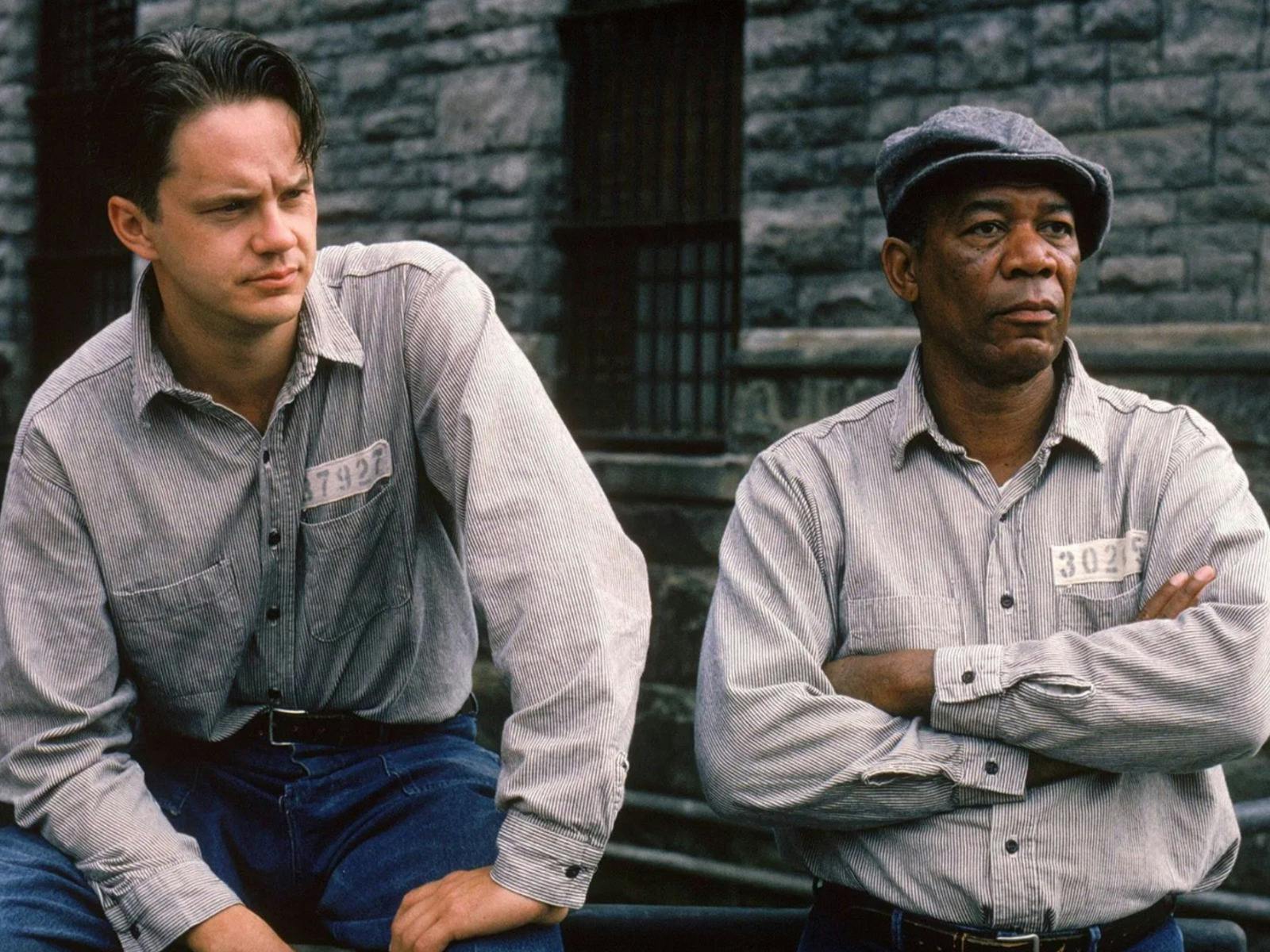 Two men dressed in prison shirts