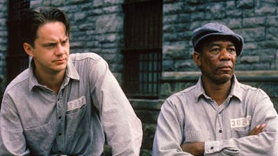 Two men dressed in prison shirts