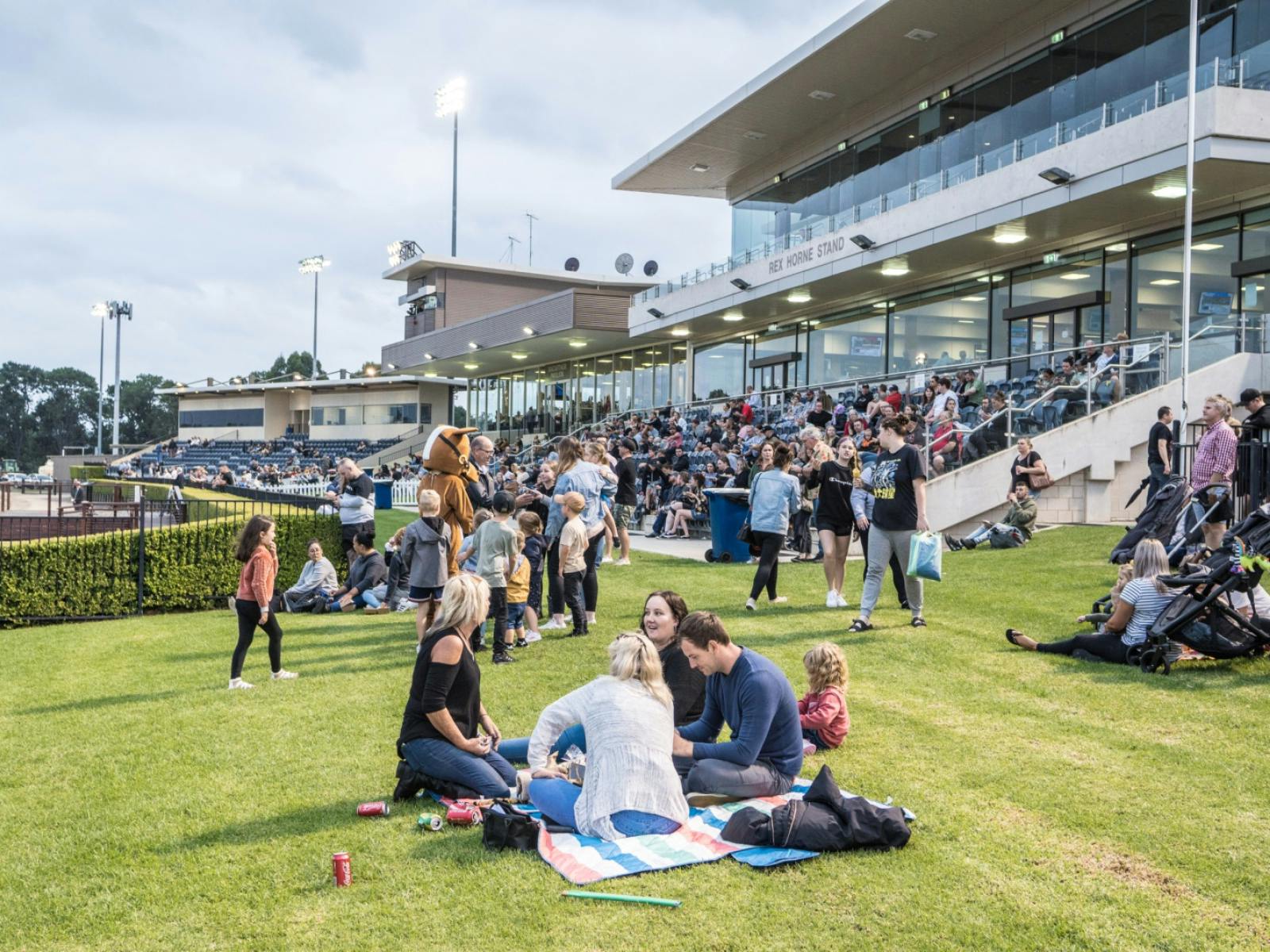 People sitting on the lawn at Club Menangle Horse Racing event