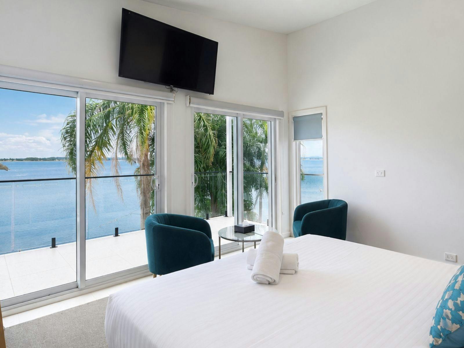 Spacious lakefront room featuring a queen bed, private balcony access, floor-to-ceiling windows