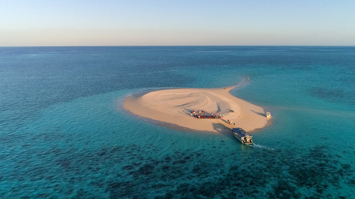 Sunset drinks at Sudbury Cay, Xplorer Vessel dropping guests at beach