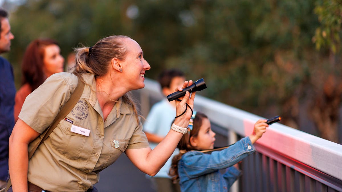 Tour guide and young girl spotlighting wildlife