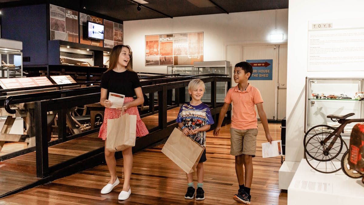 Three children walking through exhibition display