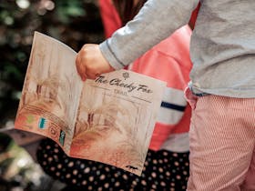 Child holding The Cheeky Fox Trail guide book
