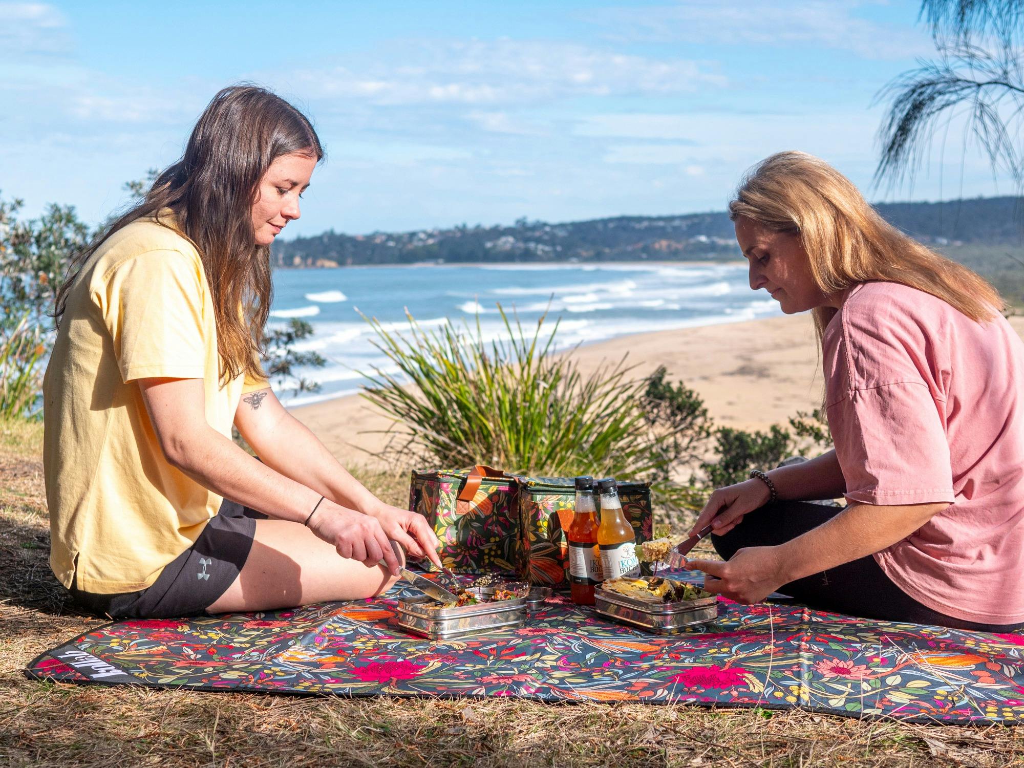 Two guests enjoying a picnic with views overlooking Tathra Beach
