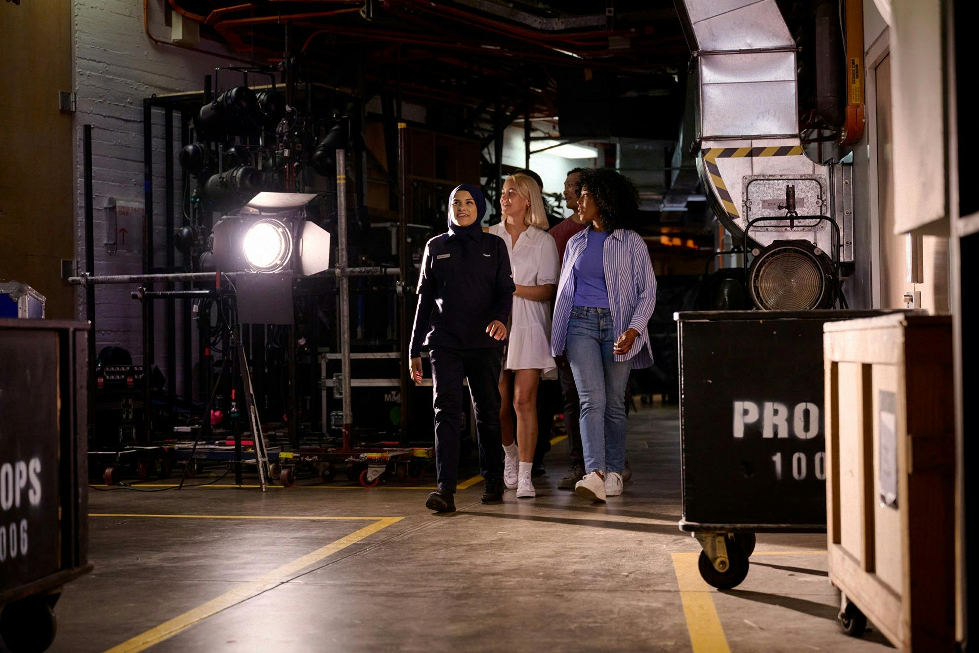 A tour guide leading a group backstage at the Opera House