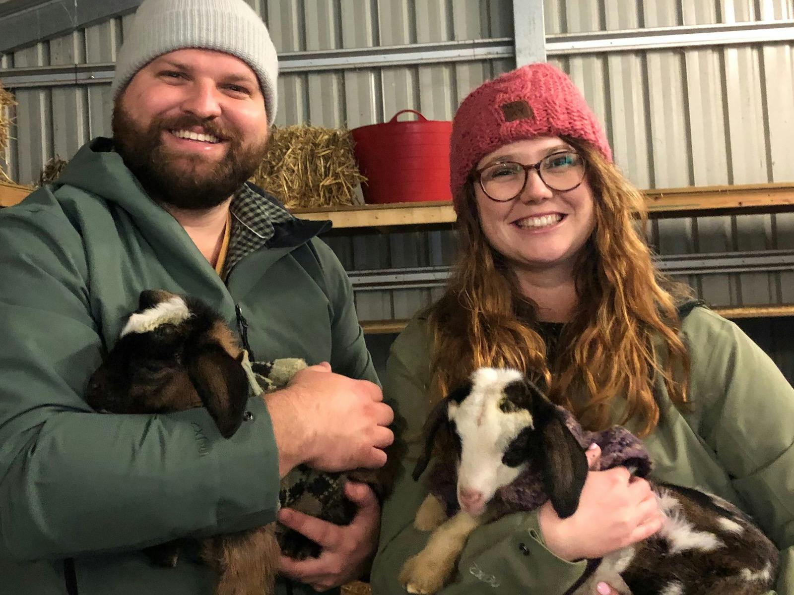 Couple holding baby goats
