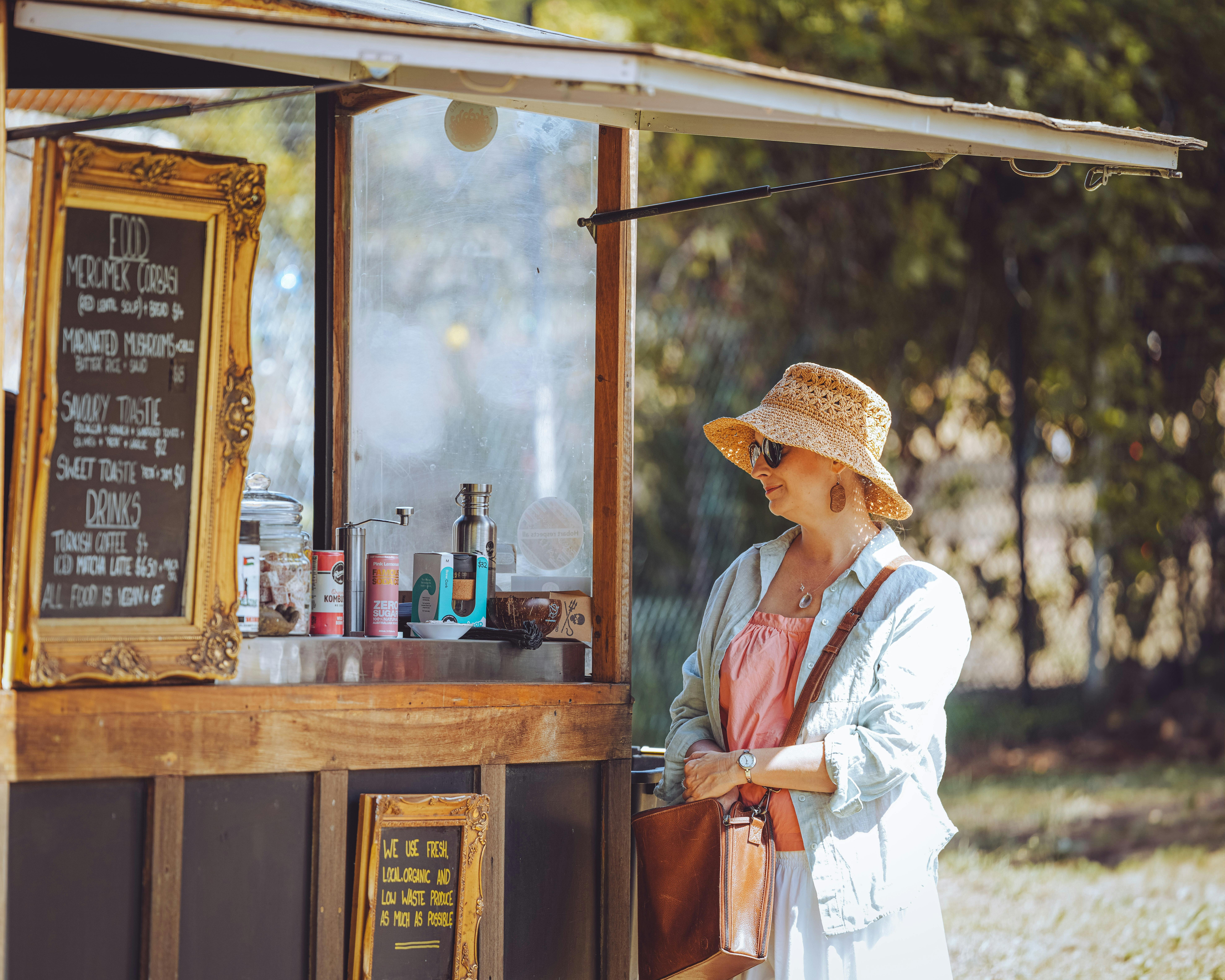 A woman views the menu at an outdoor food van.