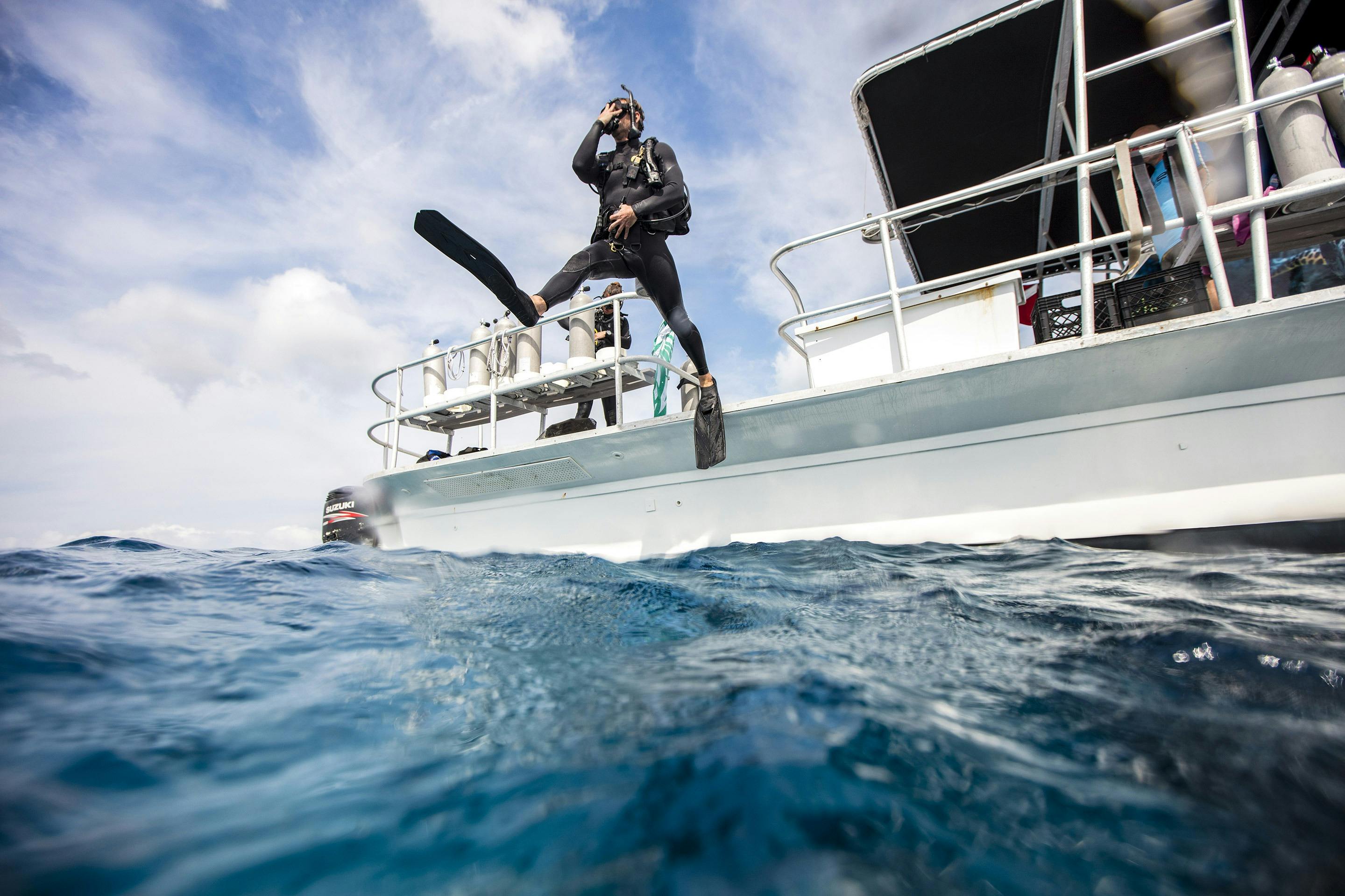 Scuba Diver steps into the water from boat