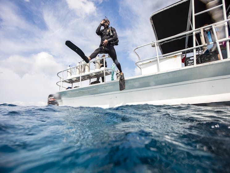 Scuba Diver steps into the water from boat