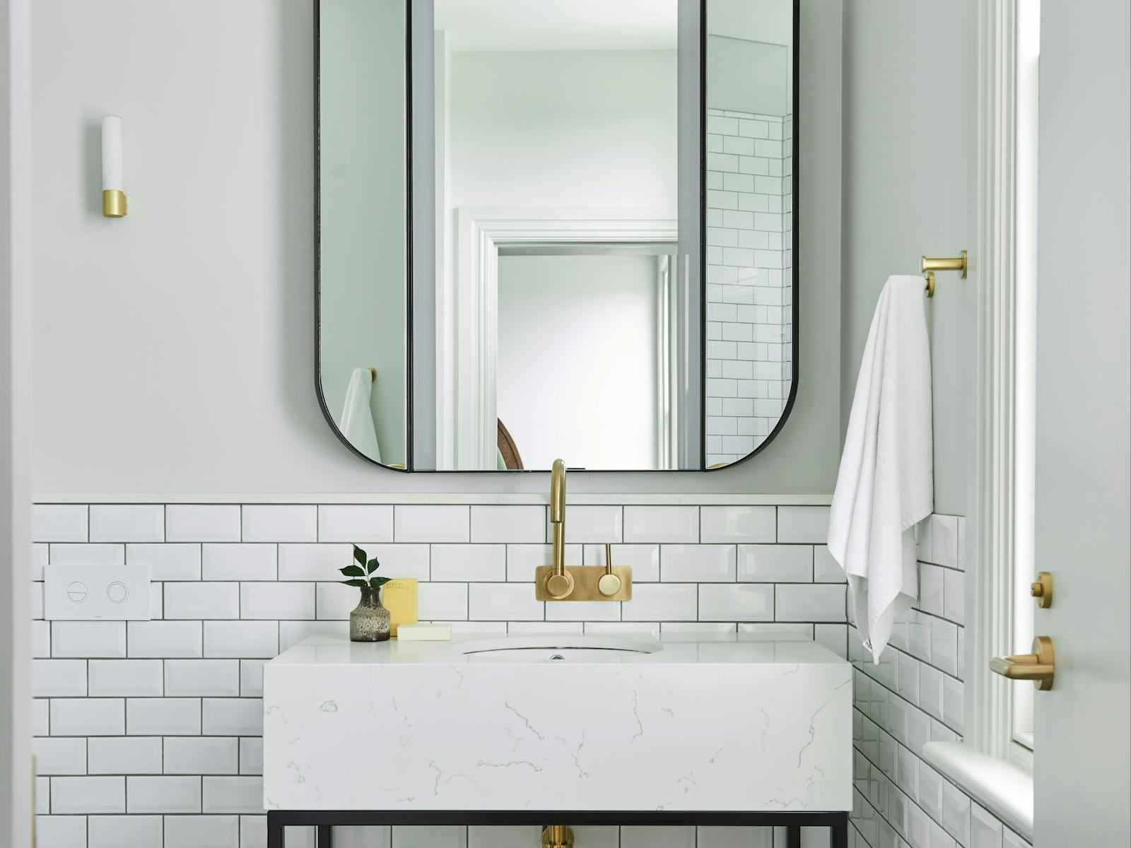 Bathroom mirror and vanity with brass fixtures