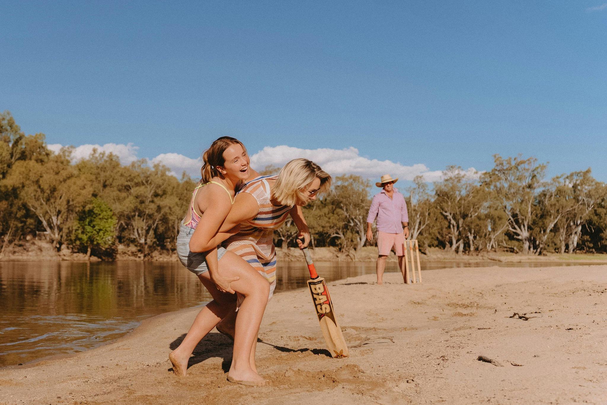 A mother and father playing beach cricket at Carters beach Ulupna