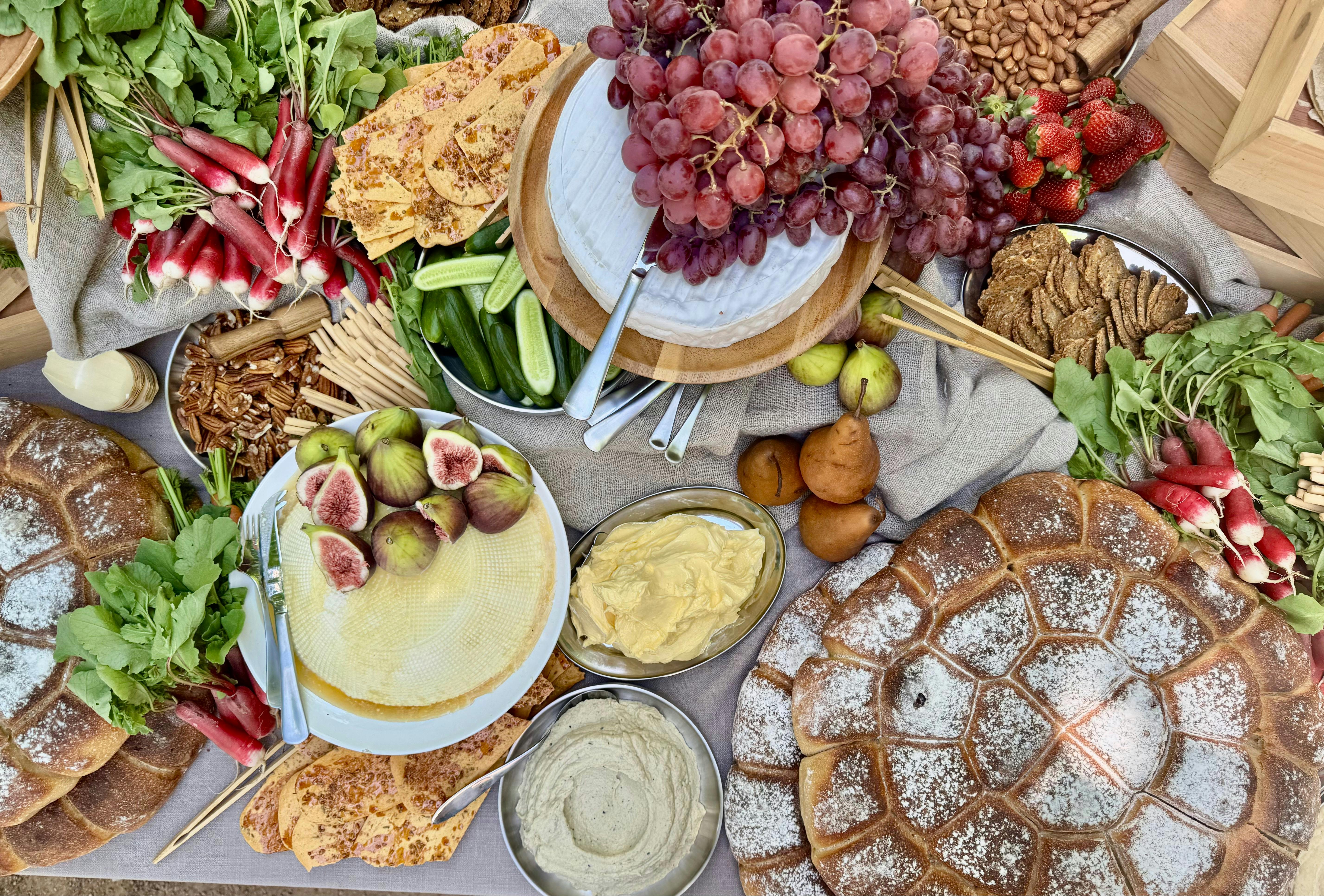A grazing table with breads, fruits, cheeses and dips
