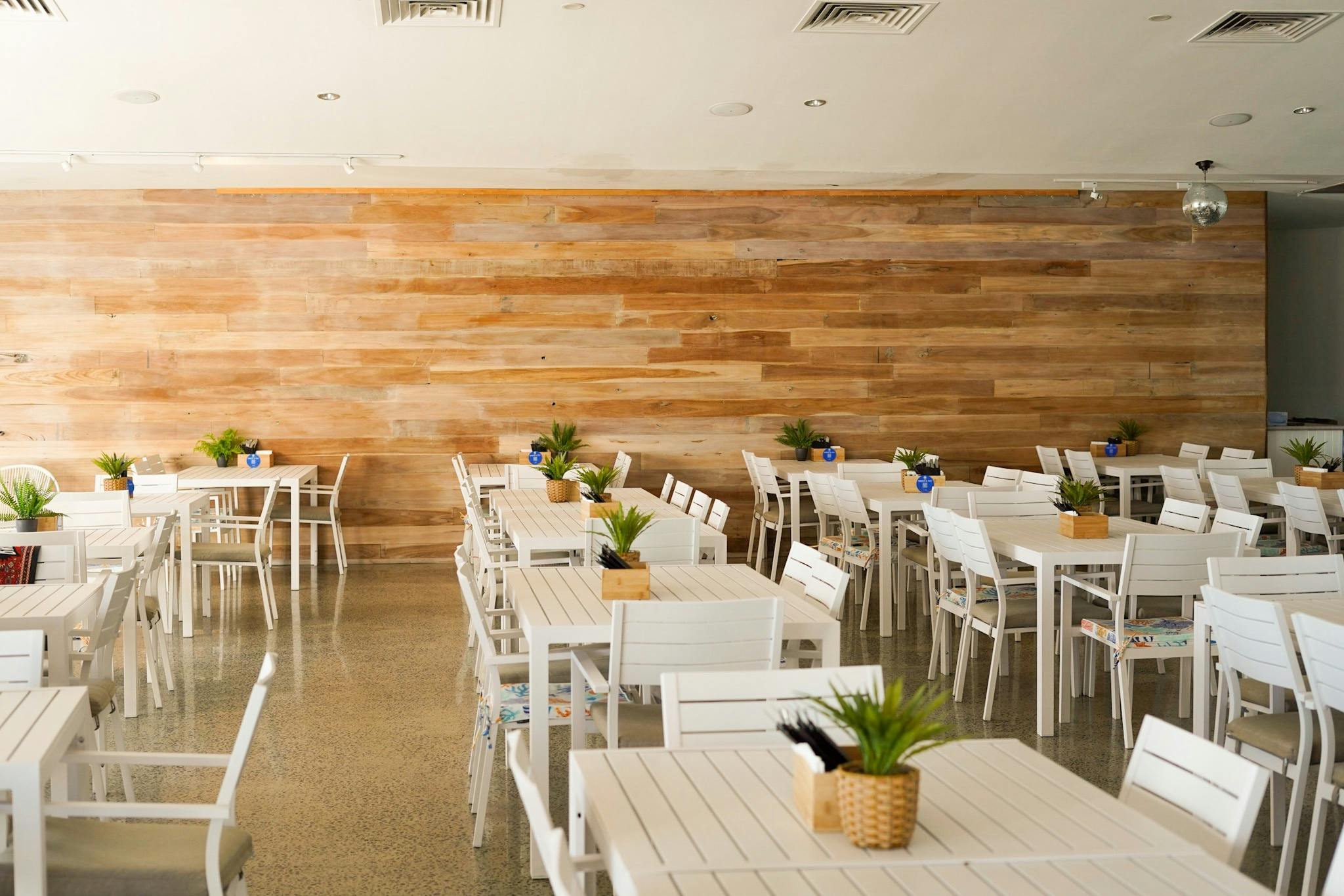Many white tables and chairs for inside dining