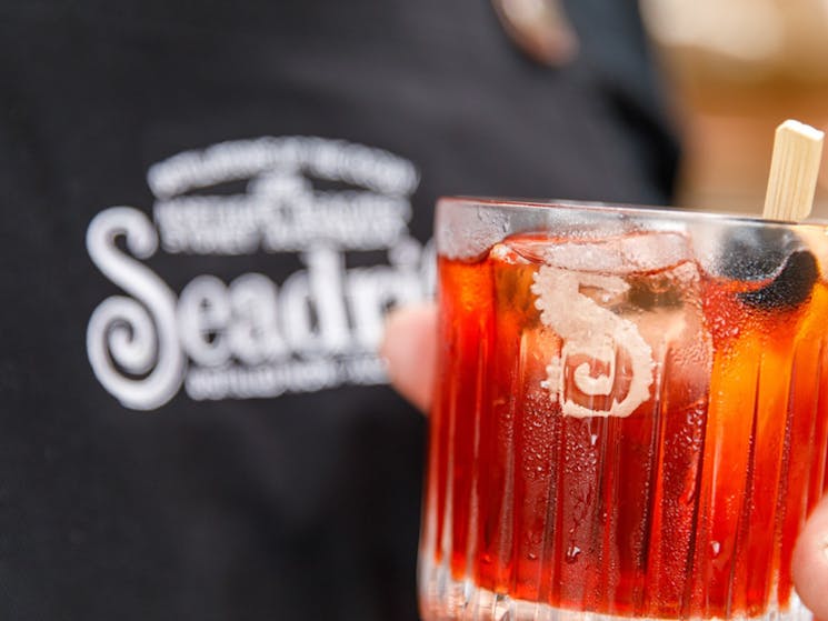 Negroni Cocktail garnished with a Marachino Cherry and Seadrift branded ice