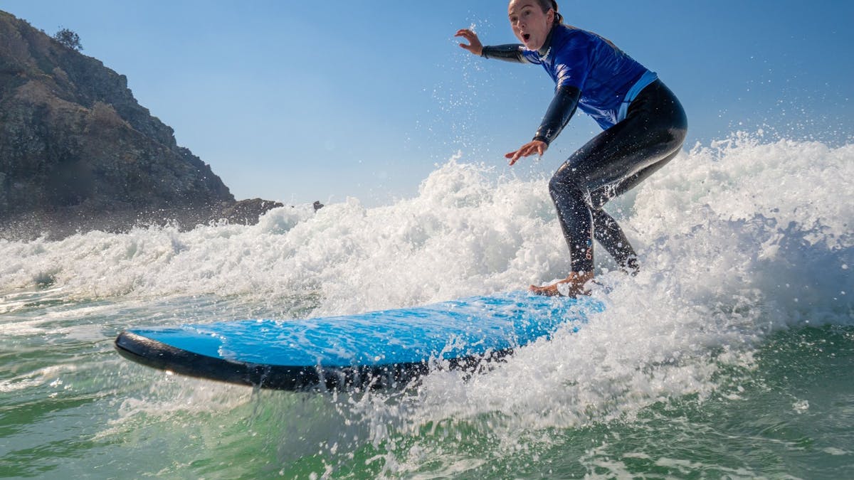Girl in a wetsuit surfing a wave