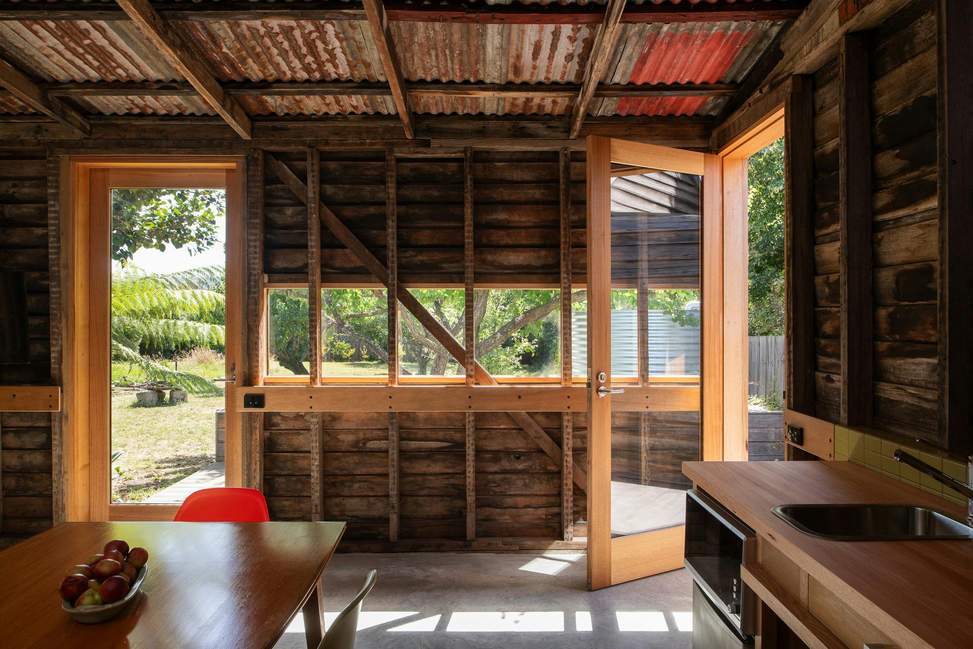 dining kitchen area with horizontal window and open glazed door looking towards garden